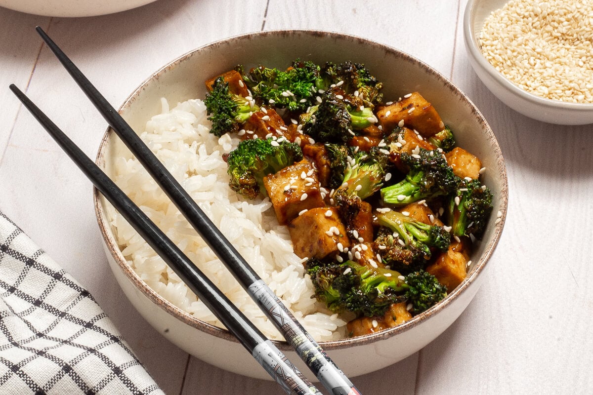 tofu broccoli stir fry over white rice in a bowl