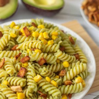 Vegan Avocado Pasta with Tofu Bacon on a table