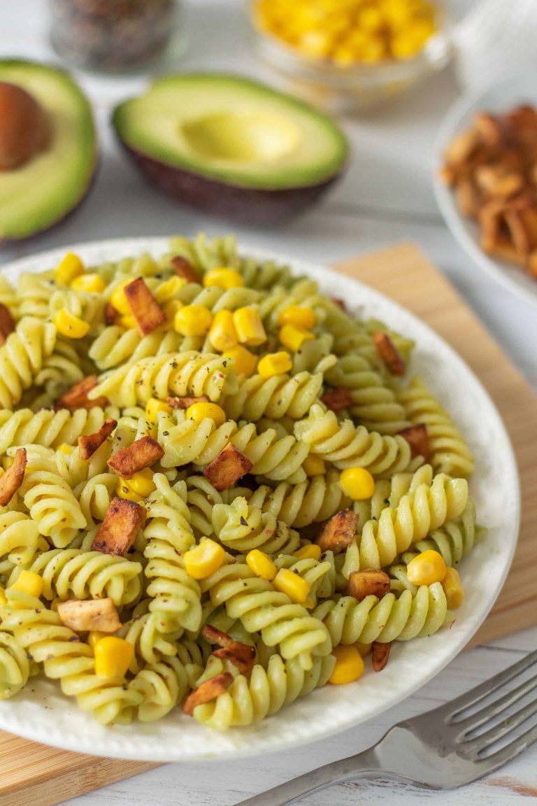 Vegan Avocado Pasta with Tofu Bacon on a table