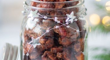 Gingerbread Candied Nuts in a jar in front of Christmas lights