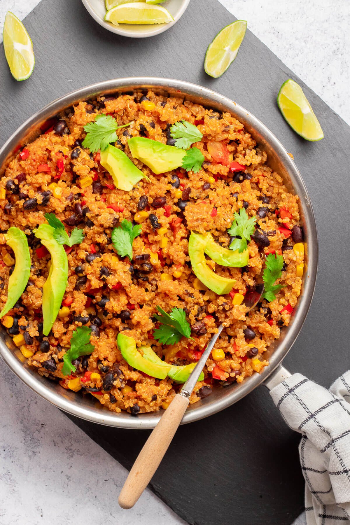 mexican quinoa in a pan with lime wedges